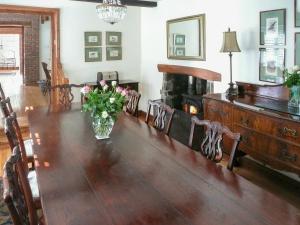een eetkamer met een tafel met een vaas met bloemen bij Dove Cote House in Westleigh