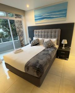 ダーバンにあるSea Lodge G01の大きなベッドと枕のある寝室