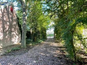 a brick road with trees on either side at Boerderijlodge Kamperland in Kamperland