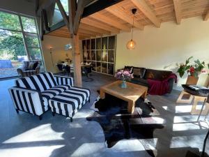 a living room with two chairs and a table at Boerderijlodge Kamperland in Kamperland