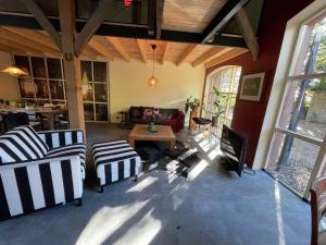 a living room with two chairs and a tv at Boerderijlodge Kamperland in Kamperland +34 photos
