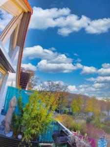 un balcon de maison avec un ciel bleu et des nuages dans l'établissement Ferienwohnung zwischen Nürnberg und Seenland, à Weißenburg in Bayern