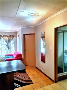 a living room with a table and red chairs at M Gold Apartments in Pretoria