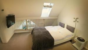 une chambre avec un lit avec une fenêtre et une télévision dans l'établissement Ferienwohnung zwischen Nürnberg und Seenland, à Weißenburg in Bayern