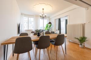 a dining room with a wooden table and chairs at Spacious City View Apartment - Prime Location Biel in Biel