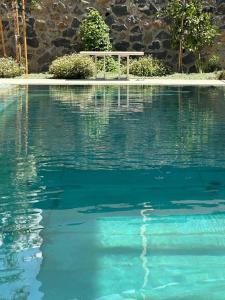una piscina di acqua blu con una panchina di Tzafona Villa, Katzrin a Qatzrin