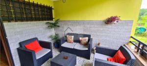 eine Terrasse mit 2 Stühlen, einem Sofa und einem Tisch in der Unterkunft Villa Teresa in Cangas de Onís