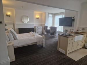 a bedroom with a bed and a desk and a television at Southcliffe hotel in Bridlington