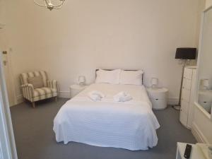 a bedroom with a white bed with two towels on it at Southcliffe hotel in Bridlington