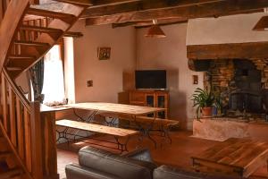 een woonkamer met een houten tafel en een open haard bij Gîtes calmes écologiques in Saint-Symphorien