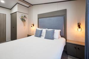 a bedroom with a large white bed with blue pillows at Sandy Lane 20 in York