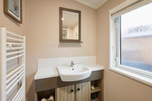 a bathroom with a sink and a window at Sandy Lane 20 in York +33 photos