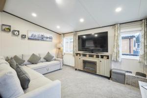 a living room with a white couch and a television at Sandy Lane 20 in York
