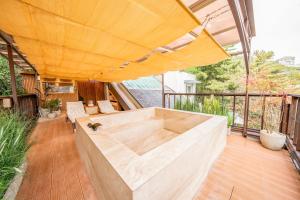 eine Außenterrasse mit einem großen gelben Sonnenschirm in der Unterkunft Bs Urban Retreat Garden And Spa Near Gyeongbokgung in Seoul