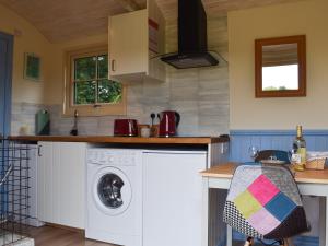 a kitchen with a washing machine and a washer at The Shepherd's Hut in Herstmonceux