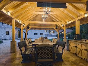 a wooden pavilion with a long table and chairs at Domeniul Caprioara in Căprioara