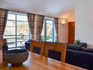 een woonkamer met een blauwe bank en een tafel bij Riccal Heads in Lastingham