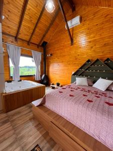 1 dormitorio con 1 cama grande y bañera en Chico Cabanas, en Lajeado Grande