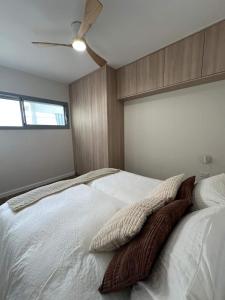 una camera con letto bianco e ventilatore a soffitto di Tzafona Villa, Katzrin a Qatzrin Altre 19 foto