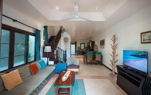 a living room with a couch and a flat screen tv at Maenam Hills Samui in Koh Samui 