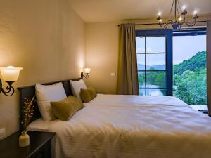a bedroom with a large bed with a large window at Domeniul Caprioara in Căprioara +66 photos