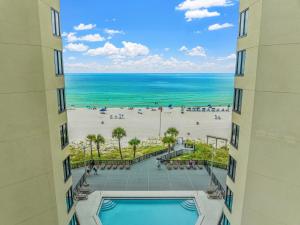 een uitzicht op het strand tussen twee gebouwen bij Seaside Shanty in Panama City Beach