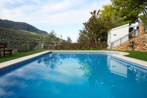 a swimming pool with blue water in a yard at Fuente Los Avellanos in Villanueva del Arzobispo