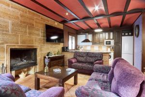 a living room with purple couches and a kitchen at Fuente Los Avellanos in Villanueva del Arzobispo