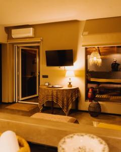 a living room with a television and a table at QUIETE e MARE in San Vito lo Capo