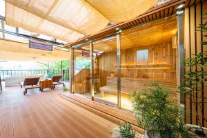 eine überdachte Terrasse mit Bank und Tisch in der Unterkunft BS Urban Retreat Garden and Spa near Gyeongbokgung in Seoul