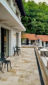 a patio with benches and tables on a building at Domeniul Caprioara in Căprioara