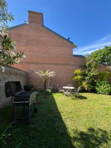 a yard with a brick building with a grill and a table at Casa Illia relax in Funes