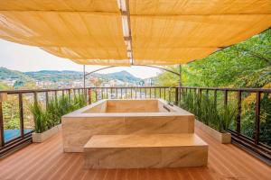 eine Holzterrasse mit Badewanne auf einem Balkon in der Unterkunft Bs Urban Retreat Garden And Spa Near Gyeongbokgung in Seoul