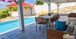 un patio con tavolo e sedie accanto alla piscina di Villa Outaouais a Bielle