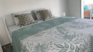 un letto con coperta e cuscini verdi e bianchi di Villa Outaouais a Bielle