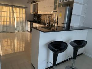 a kitchen with two black stools at a counter at Quinta descansar in Concepción del Uruguay