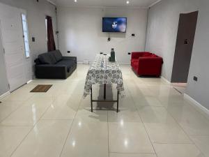 a living room with a table and a red couch at Quinta descansar in Concepción del Uruguay