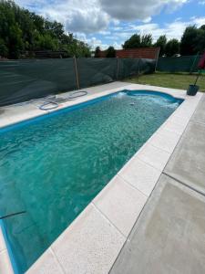 a swimming pool with blue water in a backyard at Quinta descansar in Concepción del Uruguay