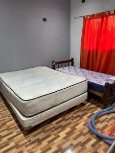 two twin beds in a room with a red curtain at Quinta descansar in Concepción del Uruguay +21 photos