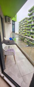 a balcony with chairs and a view of a building at Azizi Luxury Apartments - Beach Pool & Spa Resort in Mamaia Nord
