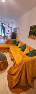 a room with three beds with yellow sheets at Azizi Luxury Apartments - Beach Pool & Spa Resort in Mamaia Nord