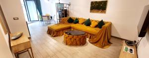 a living room with a yellow couch and a table at Azizi Luxury Apartments - Beach Pool & Spa Resort in Mamaia Nord