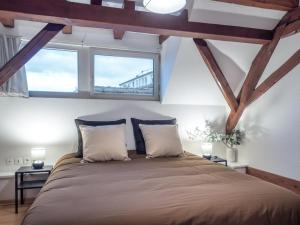 a bedroom with a large bed with two windows at Résidence de 80 m2 avec balcon & cour alsacienne - début Route des Vins in Marlenheim