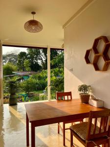 a dining room with a table and chairs and a large window at The Summer Cottage in Khlaung Phai Bae