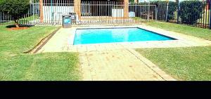 a small swimming pool in a yard next to a fence at M Gold Apartments in Pretoria