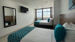 サン・アンドレスにあるHotel Tower by On vacationのベッド2台と鏡のあるホテルの部屋