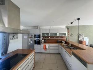 a kitchen with white cabinets and a wooden counter top at Luxuriöses Villenanwesen in ruhiger Lage in Heroldsberg