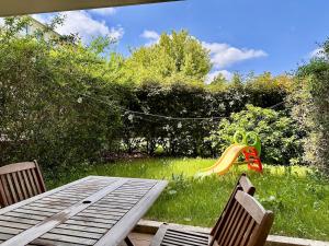 Ein Tisch, zwei Stühle und eine Spielzeugente auf dem Rasen in der Unterkunft KAALA STAYS - Family apt Disney - Paris Garden Parking in Noisy-le-Grand