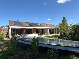 a house with solar panels on the roof at Luxuriöses Villenanwesen in ruhiger Lage in Heroldsberg