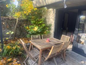 een houten tafel en stoelen op een terras bij Duplex Montmorency à 30min de Paris in Montmorency